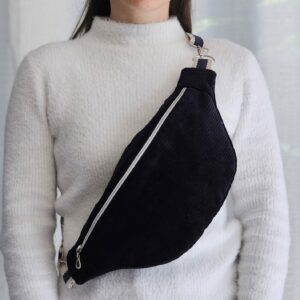 Femme portant un sac banane en velours côtelé bleu marine en bandoulière