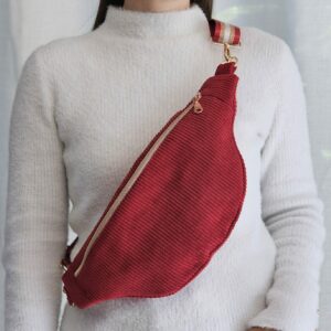 Femme portant un sac banane en velours côtelé rouge Ignis en bandoulière