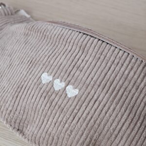 Détail de la broderie trois cœurs sur un sac banane en velours côtelé Arena