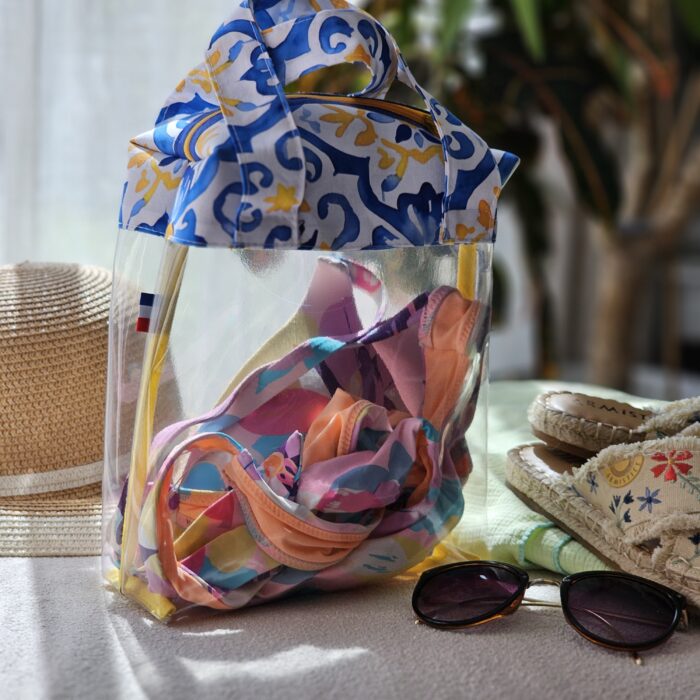 sac-maillot-transparent-azulejos-ambiance-plage.jpg Sac à maillot de bain transparent motif azulejos bleu dans une ambiance plage avec lunettes et accessoires d’été