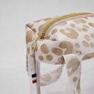 Détail du sac à maillot de bain transparent avec tissu léopard beige et fermeture éclair dorée